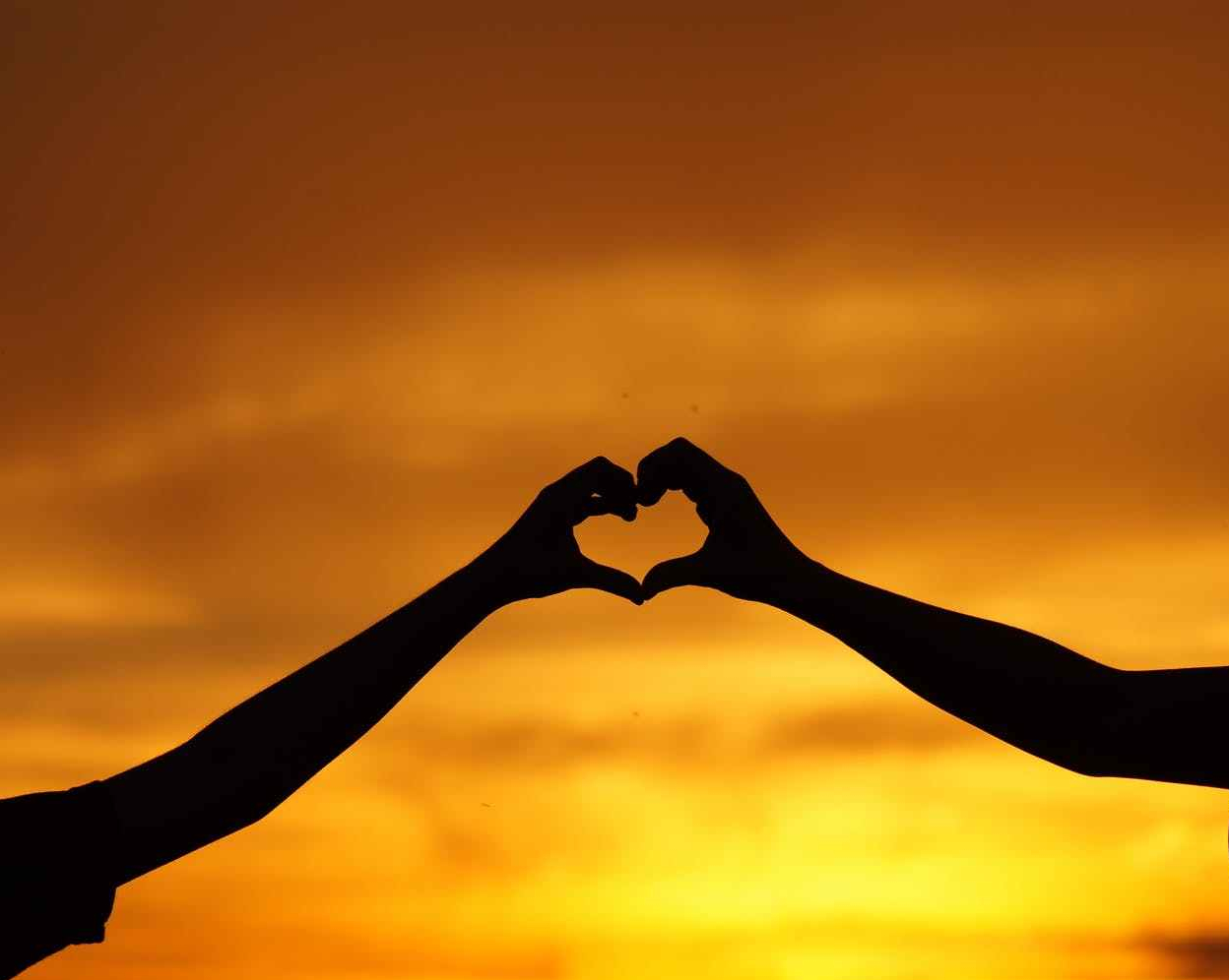 silhouette of man touching woman against sunset sky