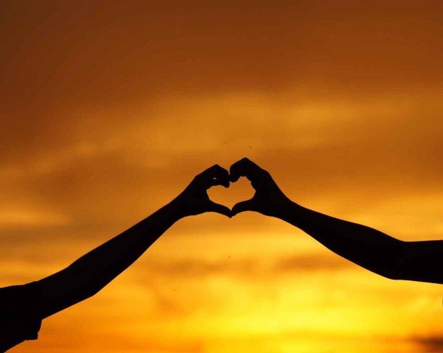 silhouette of man touching woman against sunset sky